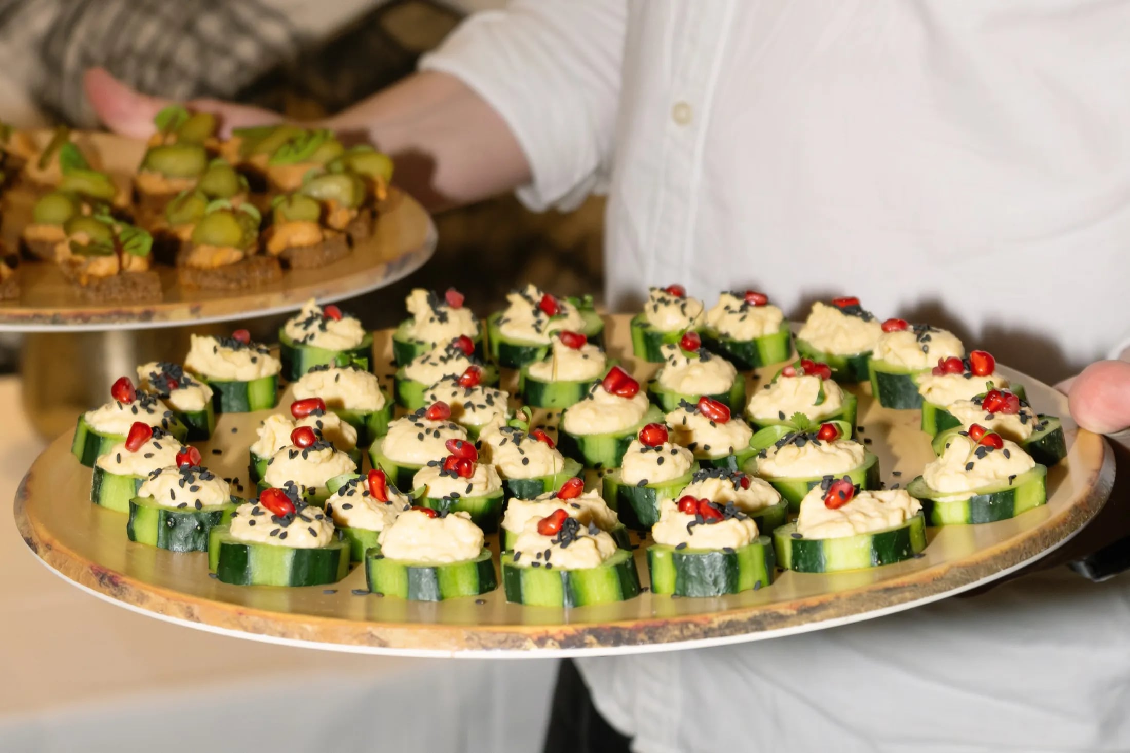 ZIMA canapés carried on platters at a private event